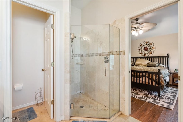 full bath featuring wood finished floors, a shower stall, a ceiling fan, and ensuite bath