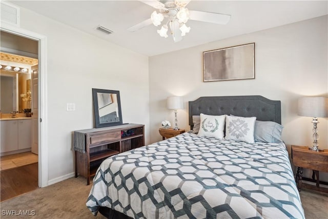 bedroom with visible vents, ceiling fan, carpet, and ensuite bath