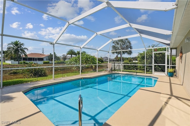 view of pool with glass enclosure and a patio