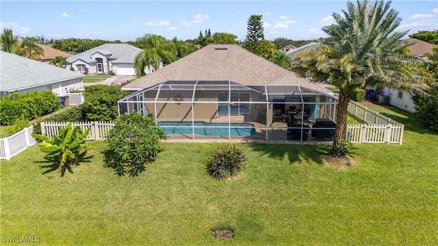 back of property featuring a lawn, a lanai, and a fenced in pool