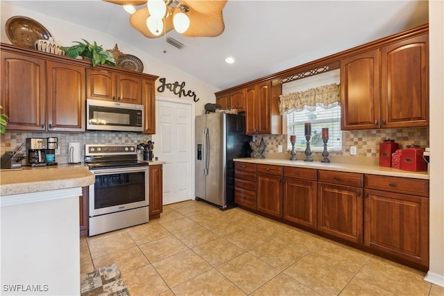 kitchen featuring stainless steel appliances, ceiling fan, tasteful backsplash, vaulted ceiling, and light countertops
