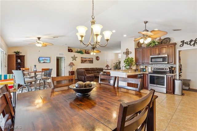 dining area with ceiling fan with notable chandelier, lofted ceiling, and light tile patterned floors