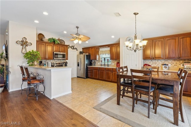 dining space featuring visible vents, light tile patterned floors, ceiling fan with notable chandelier, and recessed lighting