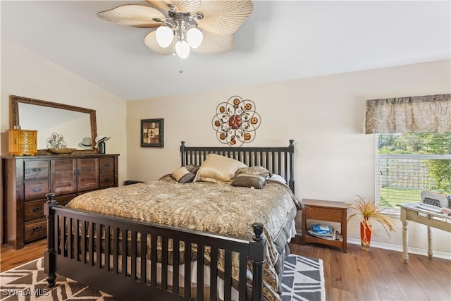 bedroom with ceiling fan, vaulted ceiling, wood finished floors, and baseboards