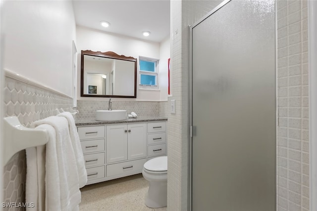 bathroom featuring decorative backsplash, vanity, toilet, and a shower with shower door