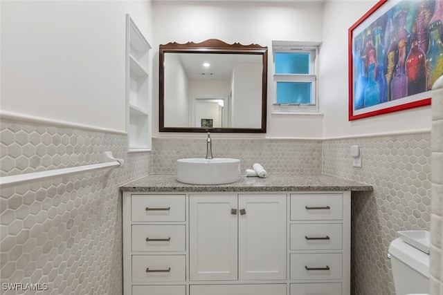 bathroom with tile walls, vanity, and toilet