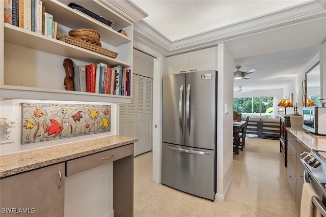 kitchen with stainless steel appliances, light stone counters, ceiling fan, and white cabinetry