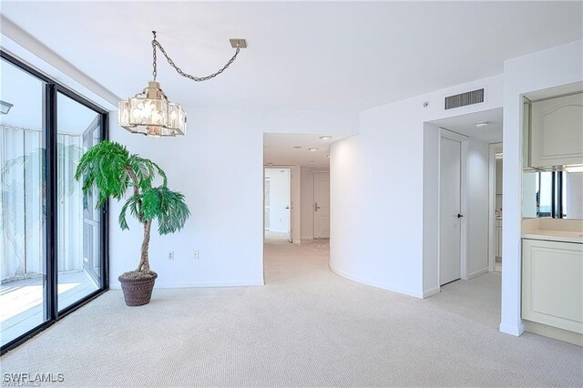 interior space with light colored carpet and a chandelier