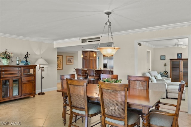 dining area featuring ceiling fan, light tile patterned flooring, and crown molding