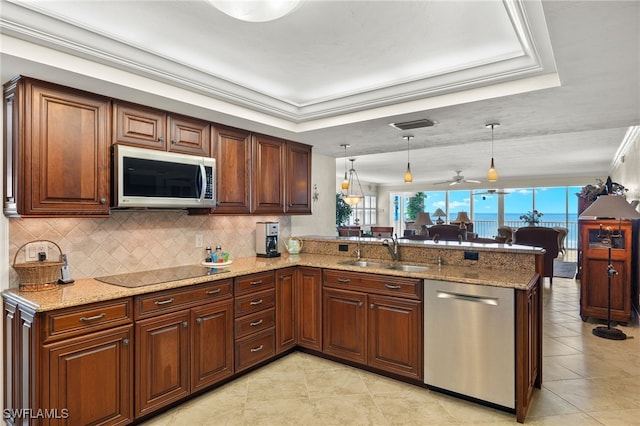 kitchen with pendant lighting, sink, kitchen peninsula, stainless steel appliances, and ceiling fan