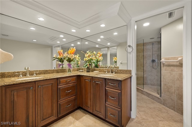 bathroom with crown molding, a tile shower, tile patterned flooring, and vanity