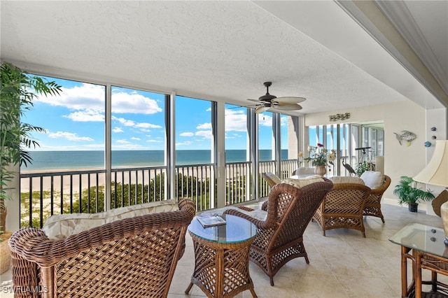 sunroom / solarium featuring a water view, a beach view, and a wealth of natural light