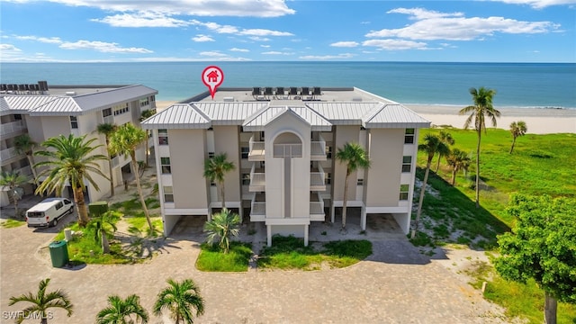 view of front of home with a water view and a beach view