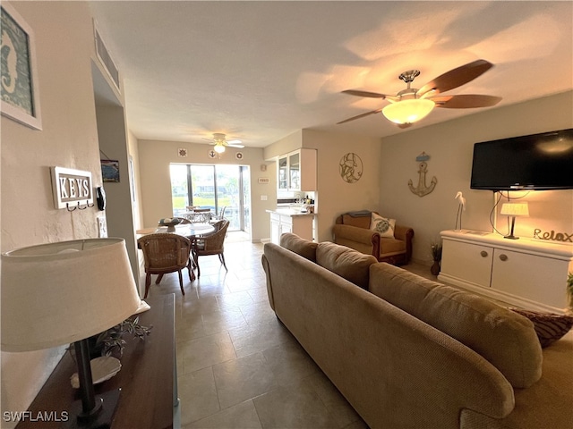 living room featuring ceiling fan and tile patterned floors