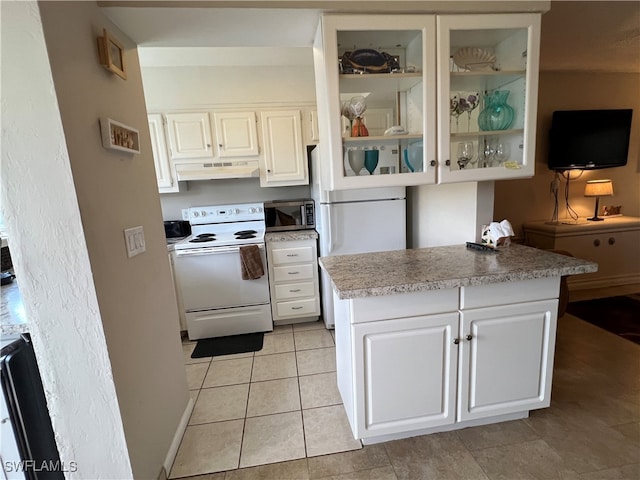 kitchen with white cabinets, light tile patterned floors, and white appliances