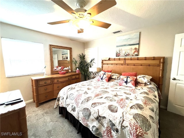 carpeted bedroom with ceiling fan and a textured ceiling