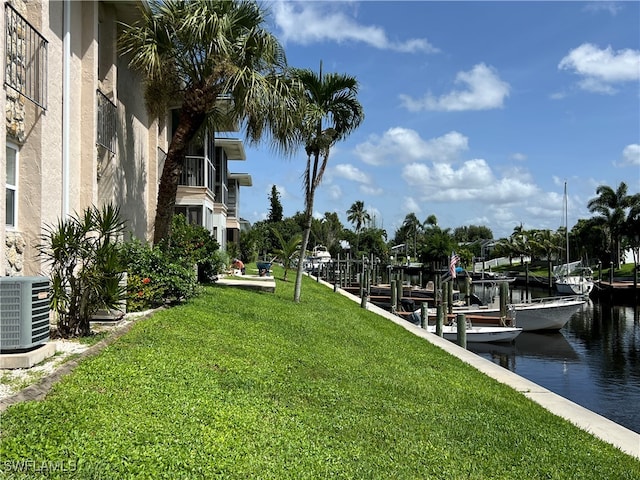 exterior space with a boat dock, a water view, and a yard