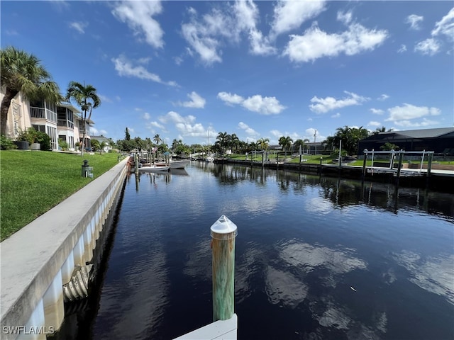 view of dock featuring a water view and a yard