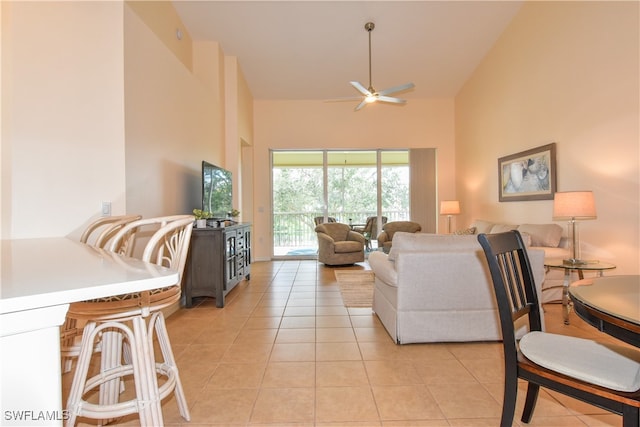 living room featuring ceiling fan, a towering ceiling, and light tile patterned floors