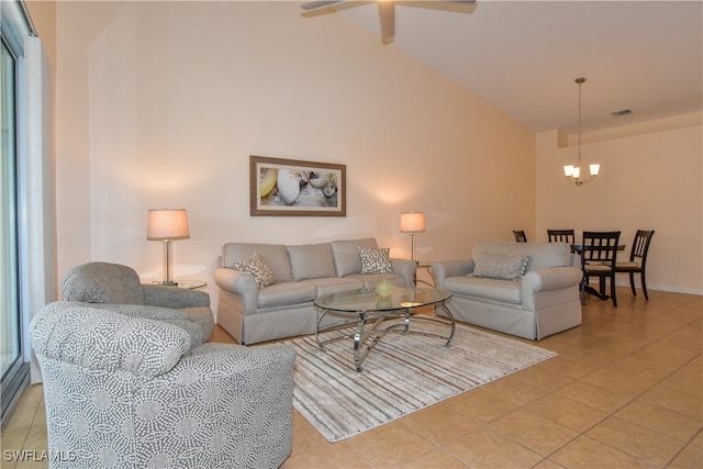 living room with ceiling fan with notable chandelier, light tile patterned floors, and high vaulted ceiling