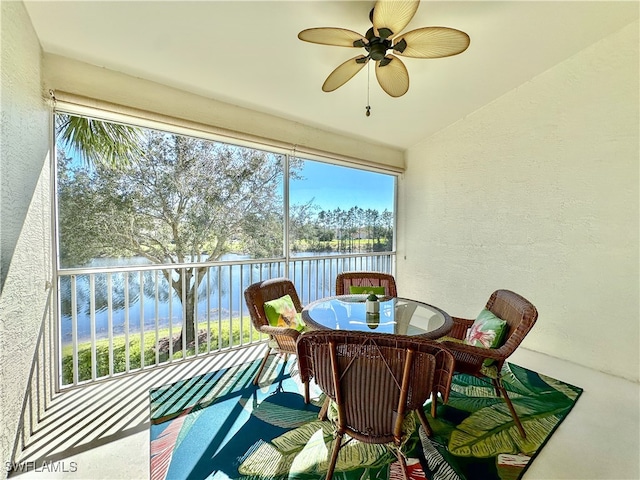 sunroom / solarium featuring a water view, vaulted ceiling, and ceiling fan