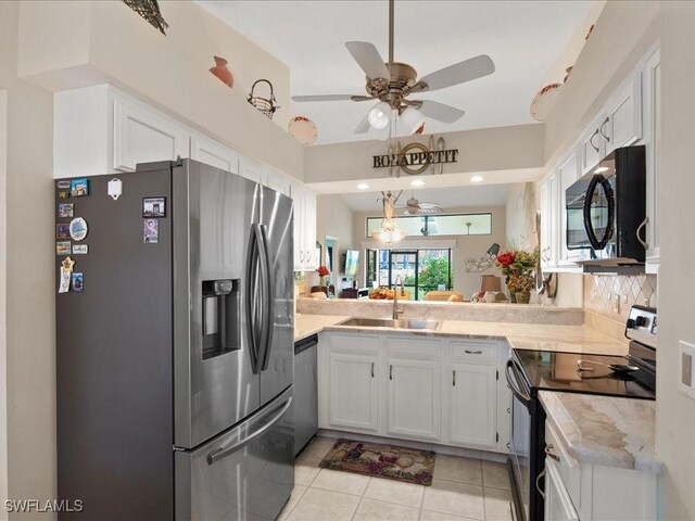 kitchen featuring appliances with stainless steel finishes, light tile patterned flooring, sink, white cabinetry, and decorative backsplash