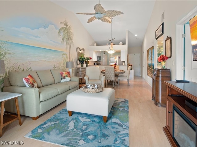 living room with light hardwood / wood-style floors, high vaulted ceiling, and ceiling fan