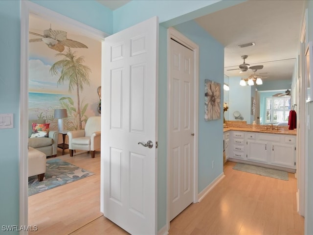 hallway featuring sink and light wood-type flooring