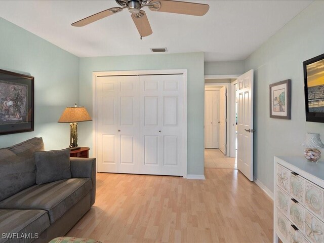 living room with light wood-type flooring and ceiling fan