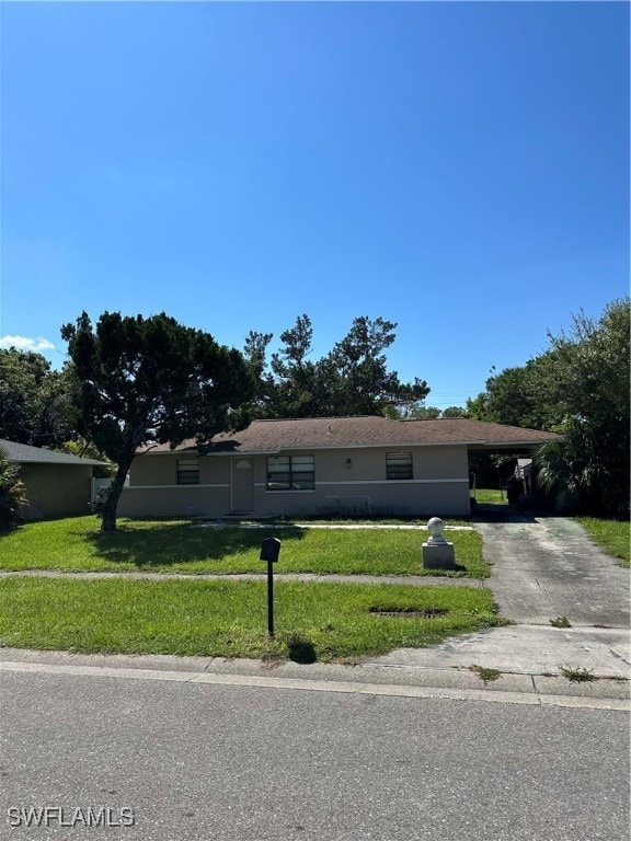 ranch-style home with a carport and a front lawn