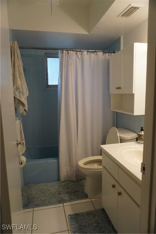 full bathroom with tile patterned floors, vanity, toilet, and shower / bath combo with shower curtain