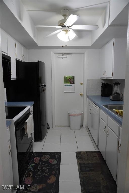 kitchen with white appliances, ceiling fan, sink, light tile patterned floors, and white cabinetry