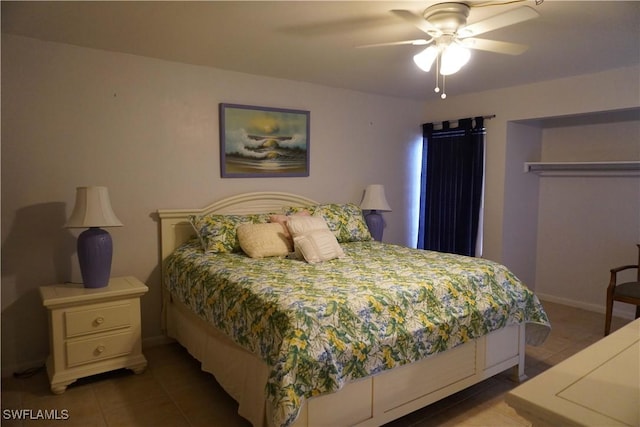 tiled bedroom with ceiling fan and a closet