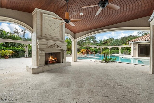 view of patio / terrace with ceiling fan and exterior fireplace