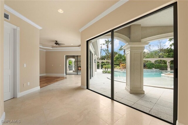 entryway with ceiling fan, plenty of natural light, light tile patterned floors, and crown molding