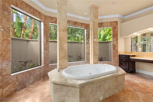 bathroom featuring tiled tub, vanity, ornamental molding, and a healthy amount of sunlight