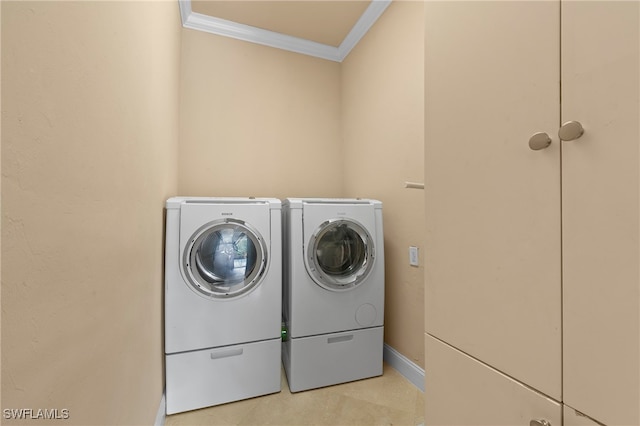 clothes washing area with washer and clothes dryer and crown molding