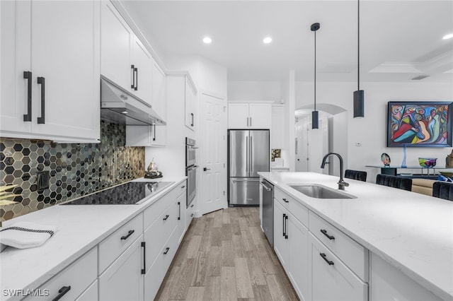 kitchen featuring stainless steel appliances, white cabinetry, sink, and pendant lighting