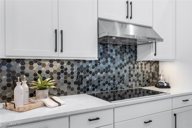 kitchen with white cabinets, black electric cooktop, exhaust hood, and decorative backsplash