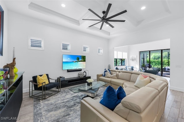 living room with coffered ceiling, ceiling fan, beam ceiling, and light hardwood / wood-style flooring