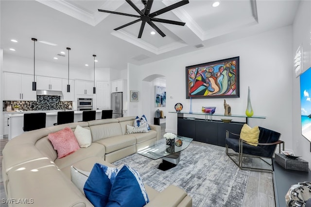 living room featuring beamed ceiling, ornamental molding, ceiling fan, and coffered ceiling