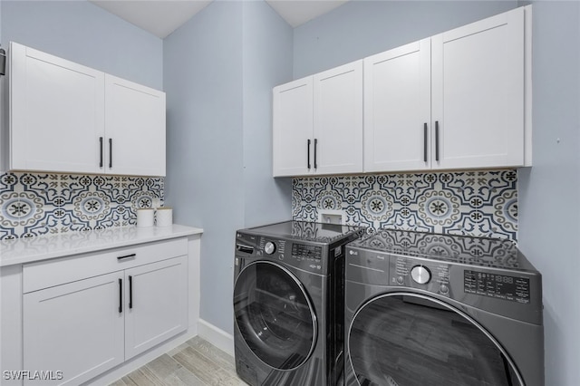 laundry room featuring light hardwood / wood-style flooring, cabinets, and independent washer and dryer