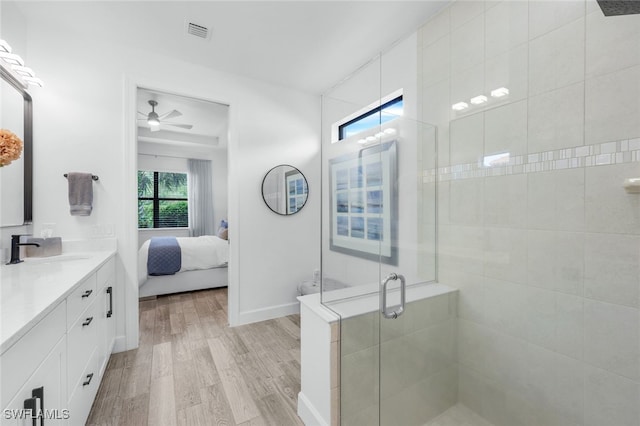 bathroom featuring vanity, walk in shower, ceiling fan, and hardwood / wood-style floors