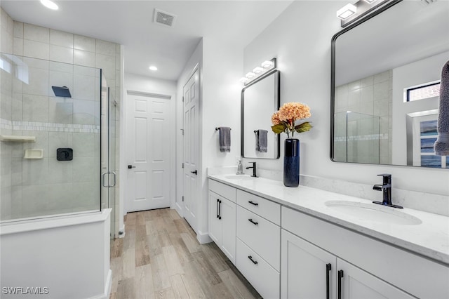 bathroom featuring a shower with door, vanity, and hardwood / wood-style floors