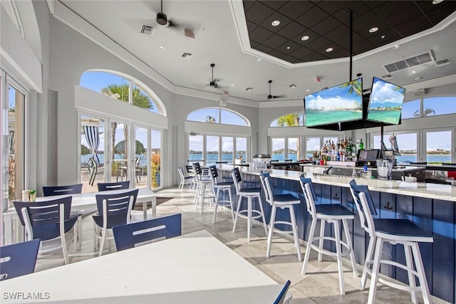 tiled dining area with a towering ceiling and ceiling fan