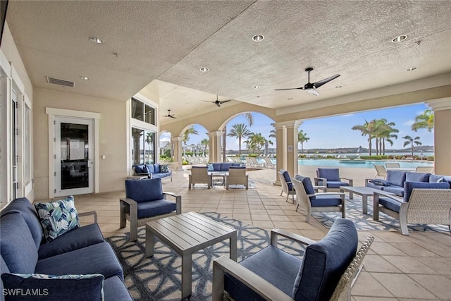 view of patio / terrace featuring ceiling fan, an outdoor hangout area, and a water view