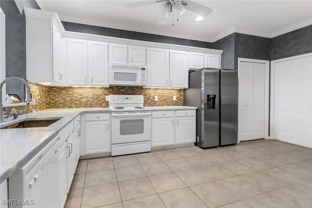 kitchen with white appliances, white cabinetry, sink, and ceiling fan