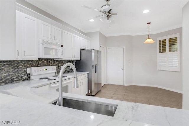 kitchen with white appliances, white cabinetry, a sink, and decorative backsplash