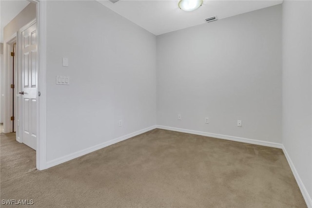 empty room with carpet, visible vents, and baseboards