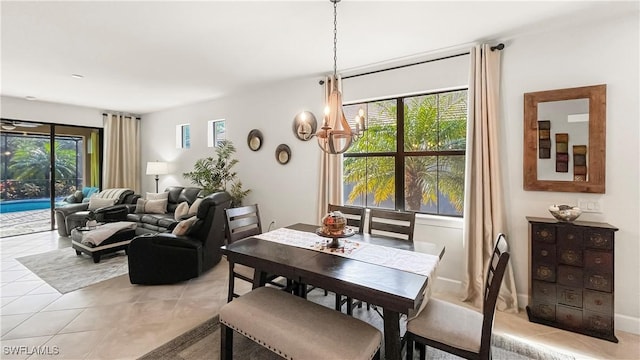 dining area with plenty of natural light, light tile patterned floors, and a chandelier